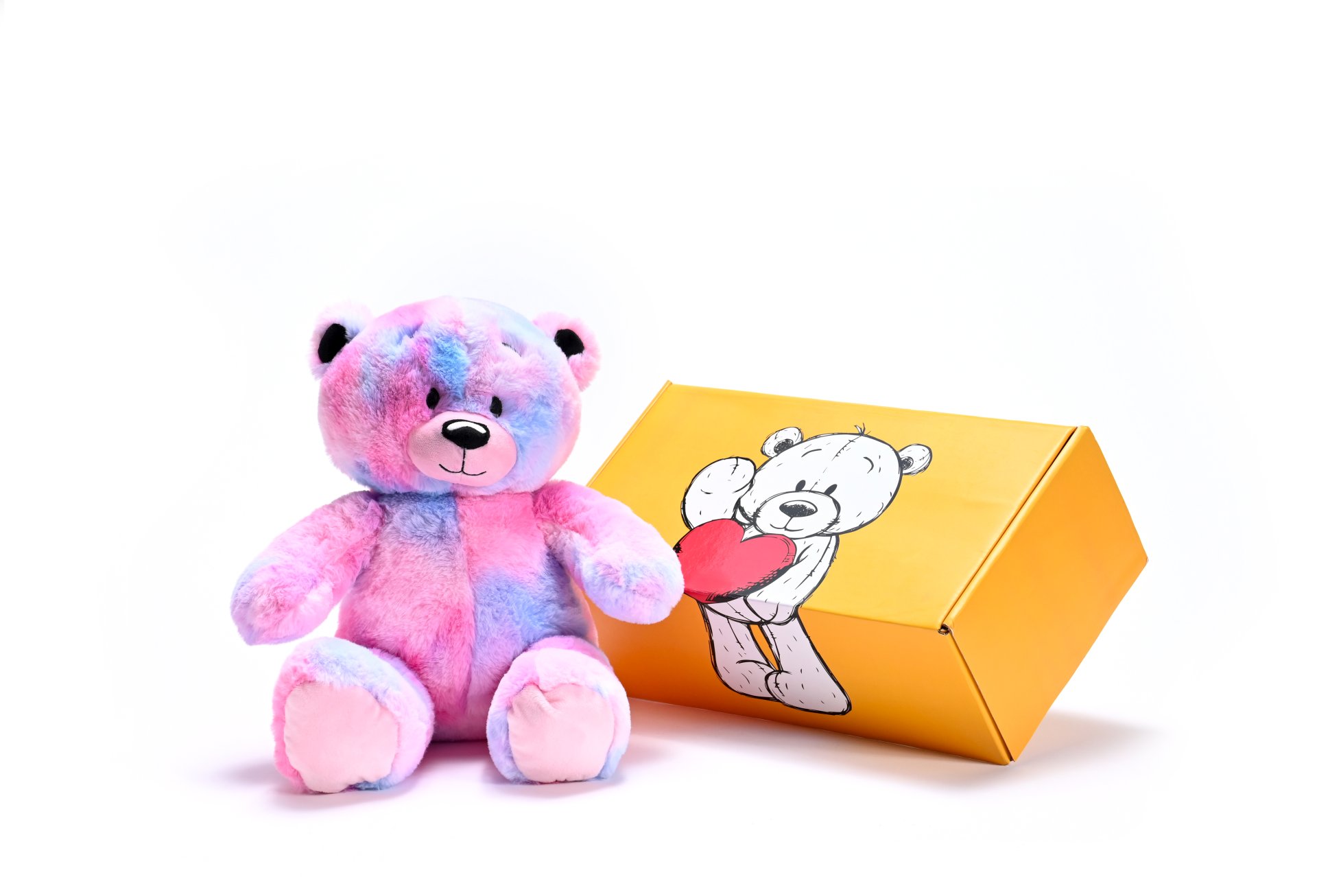a stuffed teddy bear next to a box