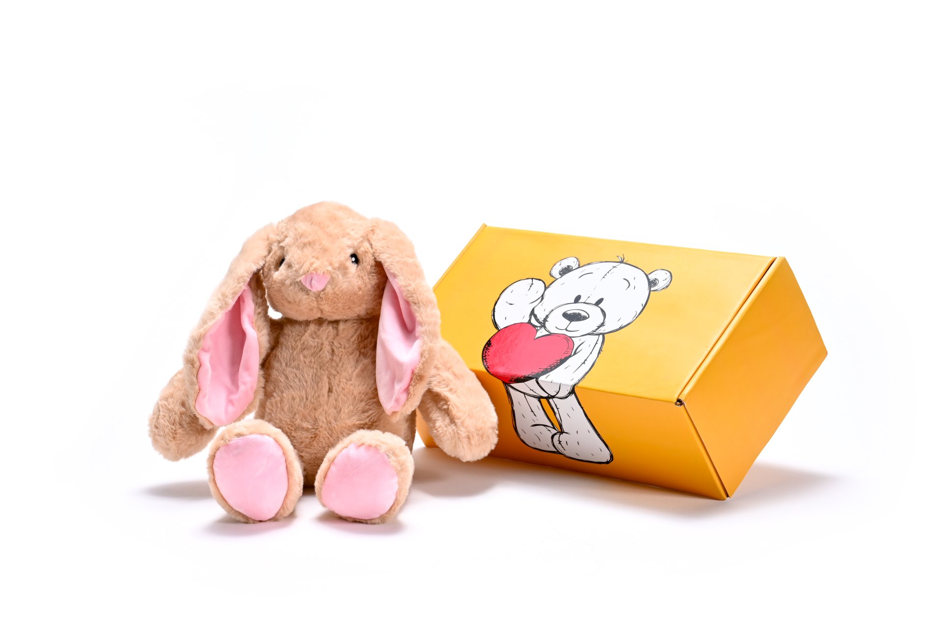 a stuffed brown bunny soft toy next to a box
