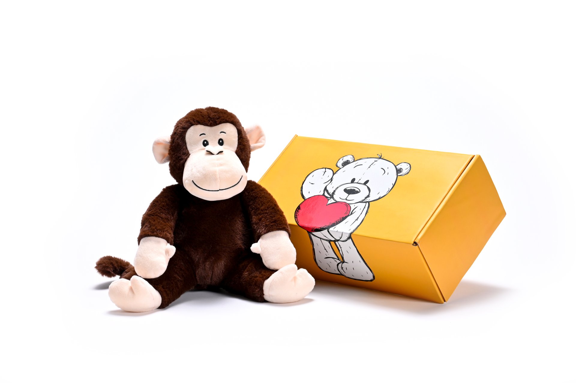 a stuffed monkey soft toy next to a box