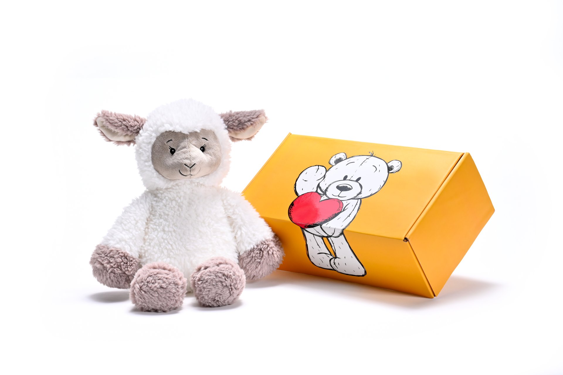 a stuffed sheep soft toy next to a box